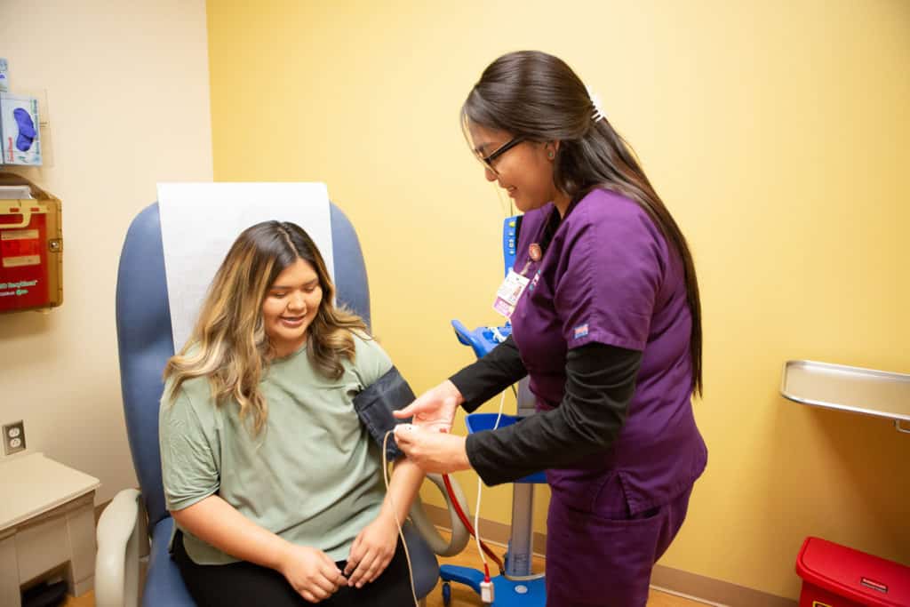 Girl getting blood pressure taken by nurse