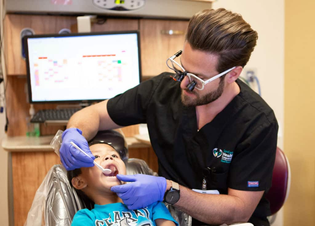 Dentist examining pediatric patient's teeth