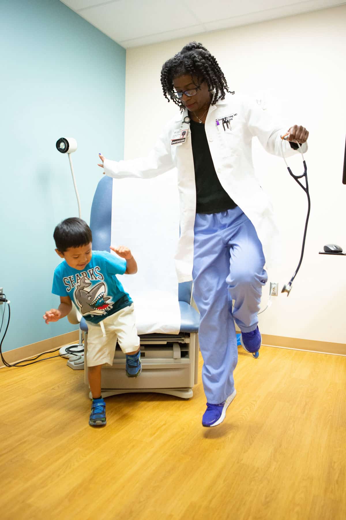 Doctor dancing with a young boy in an exam room