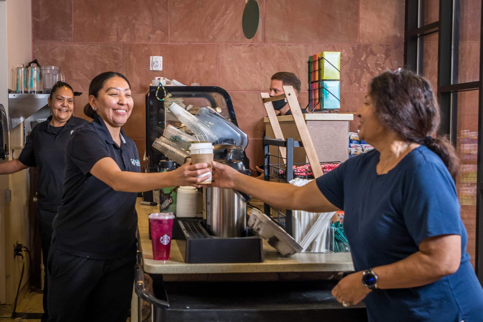 A nurse getting coffee from the Starbucks Barista